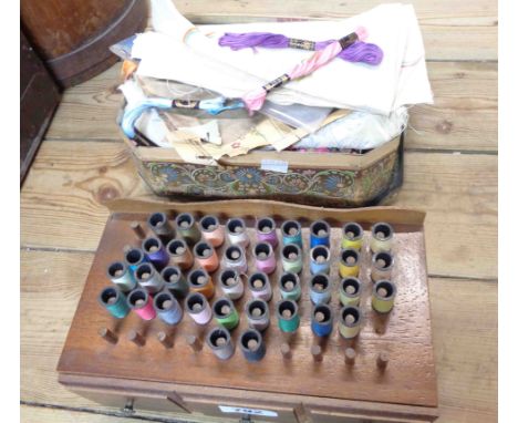 A wooden sewing box with cotton reel holders to top - sold with vintage biscuit tin containing a quantity of silks on stands