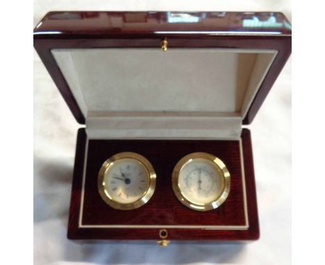 A modern timepiece and thermometer set in polished wood lift-top case
