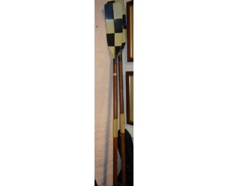 A pair of vintage rowing oars, with painted chequerboard finish