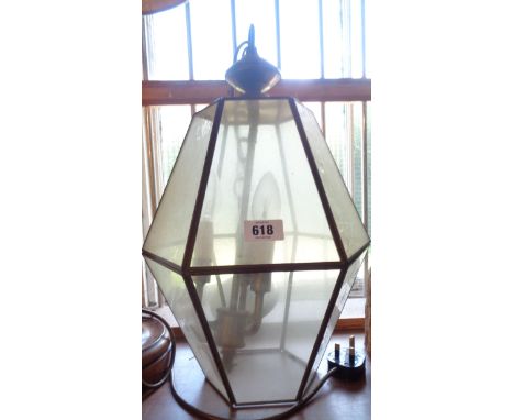 An old metal framed hanging ceiling lamp with glass panels of hexagonal form