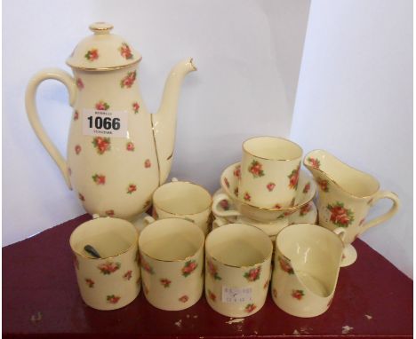 A Royal Doulton bone china coffee set with transfer printed rose decoration comprising coffee pot, cream and sugar, six coffe