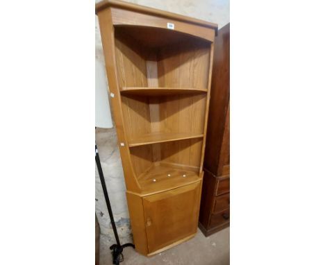 A 74cm Ercol light elm freestanding two part corner unit with two shelves and single cupboard door under