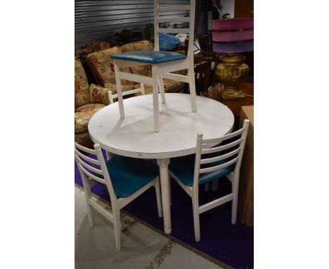 A mid century circular dining table having set of four teal seated ladder back chairs