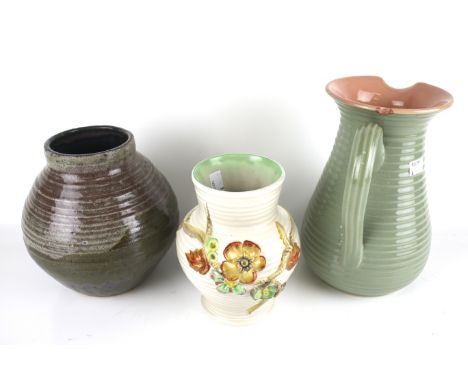 Three 20th century vases. Comprising a stoneware jug with a ribbed exterior, glazed in green and pink, H24cm, a Clarice Cliff