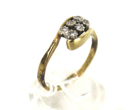 A 9ct gold and diamond six stone cross-over ring. The tiny eight-cut diamonds each illusion set in a white collet, on a yello