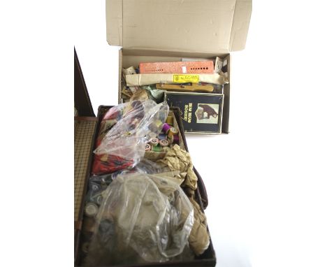An assortment of sewing items contained within a vintage leather case. Including a lacquer needle case, a carved bone bobbin 
