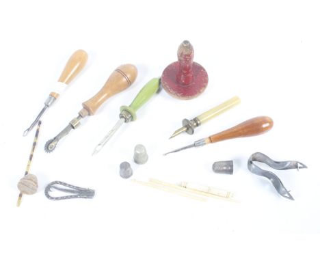 An assortment of Victorian and later sewing tools. Including silver thimbles, a bone needlecase, a buttonhook, etc.