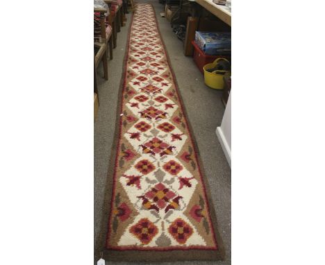 A 20th century carpet runner. Featuring pink and orange flowers on a cream and brown ground, 58cm x 750cm