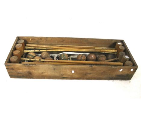 A vintage croquet set in a wooden crate. Including eight mallets stamped 'Cassiobury', nine balls and metal hoops, etc. L107c