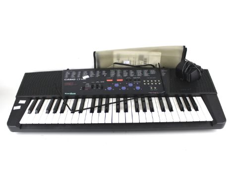 A Casio CT-400 electronic piano keyboard. With Casio AC power adaptor AD-5E and instruction booklet, 81cm long