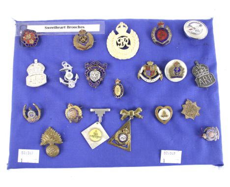 A collection of Sweetheart brooches. Including a carved bone George VI example, a mother of pearl and enamel 'Royal Navy' bad