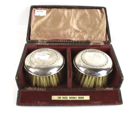 A pair of silver mounted round 'Hazel Shingle brushes'. Mark of William HAre Haseler, Birmingham 1926, in a fitted case