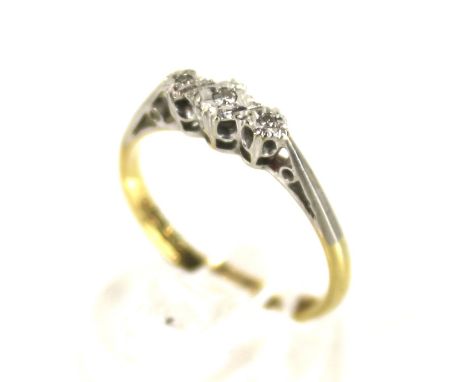 A vintage gold and diamond three stone ring. The graduated small eight-cut diamonds illusion set in white on a yellow D-secti