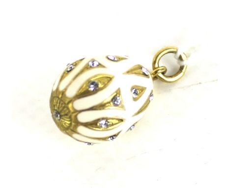A gold-plated, paste and cream-enamel egg-shaped pendant inspired by Faberge in Russian style. The cream enamelled egg with t