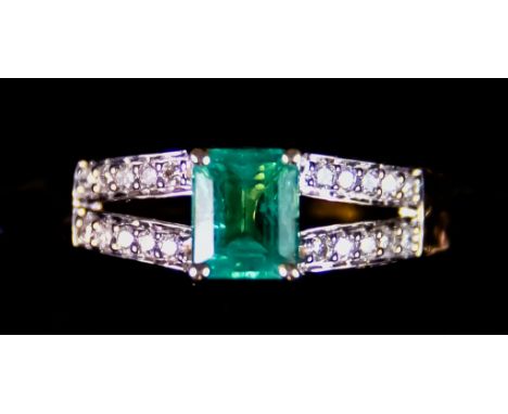 An 18ct Gold Emerald and Diamond Ring, set with a centre Ethiopian emerald, approximately .95ct, flanked by small white diamo