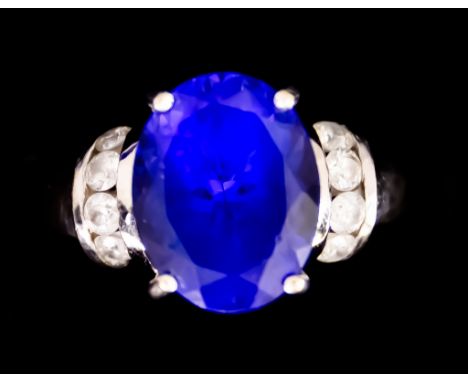 An 18ct White Gold Tanzanite and Diamond Ring, set with a centre faceted tanzanite stone, approximately 3.5ct, flanked by eig