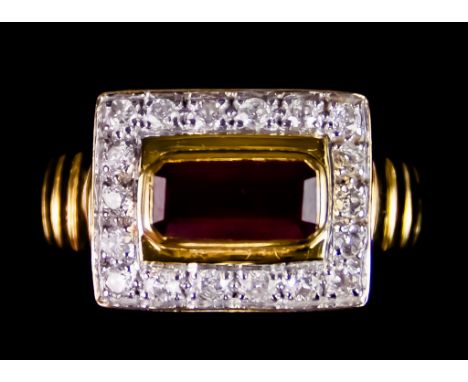 An 18ct Gold Ruby and Diamond Ring, set with a centre ruby stone, 10.2mm x 5mm, surrounded by small brilliant cut white diamo