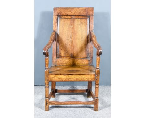 An Old Panelled Oak Armchair, with plain crest rail, raised panel to back, wood seat, on turned front legsGeneral light scatt