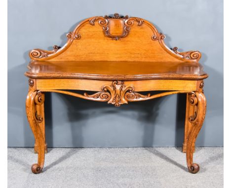 A Victorian Oak Console Table of shaped outline, the scroll and leaf carved upstand with central shield-shaped plain cartouch