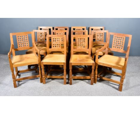 A Set of Twelve Robert "Mouseman" Thompson of Kilburn Oak Dining Chairs including two armchairs, with lattice backs, seats up