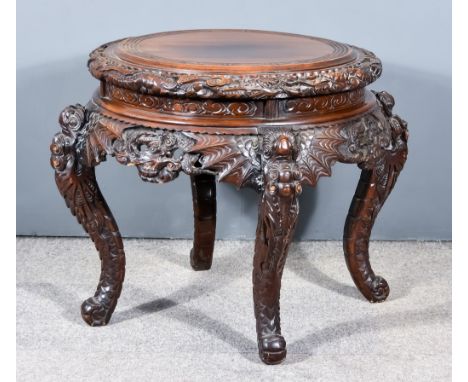A Chinese Hardwood Circular Occasional Table, the whole boldly carved with stylised dragons and cloud motif, on dragon head s
