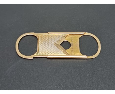 An engine turned yellow metal cigar cutter, stamped 14k, 53mm long. 