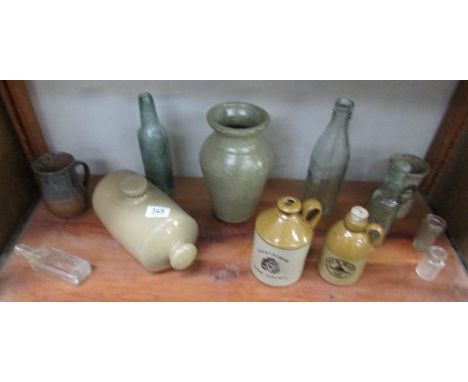 A shelf of stoneware and glass bottles.