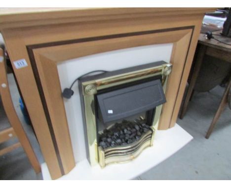 A coal effect electric fir in a light oak effect surround.