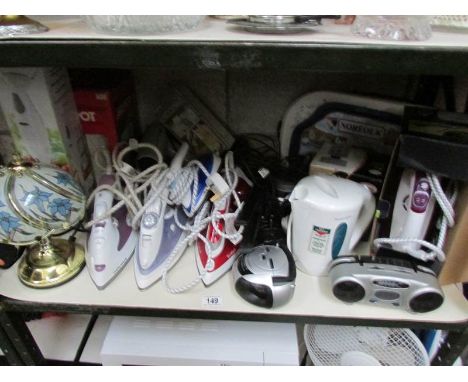 A shelf of irons, kettles etc.,