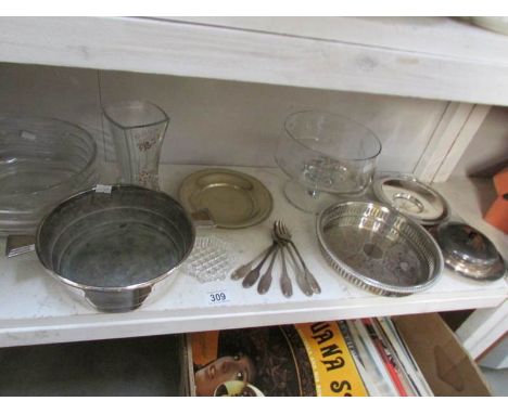 A shelf of assorted silver plate and glass.