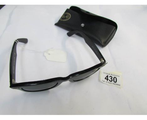 A pair of genuine Ray Ban sun glasses, marked RB on lens, small scuff to frame.