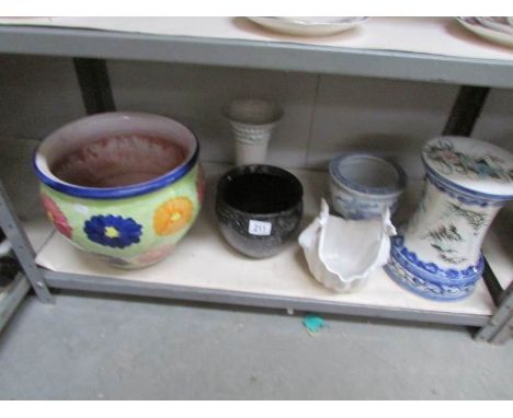 A shelf of assorted plant pots.