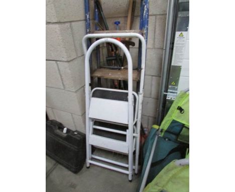 A quantity of garden tools and step ladders.