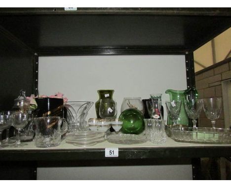 A shelf of assorted glass ware.