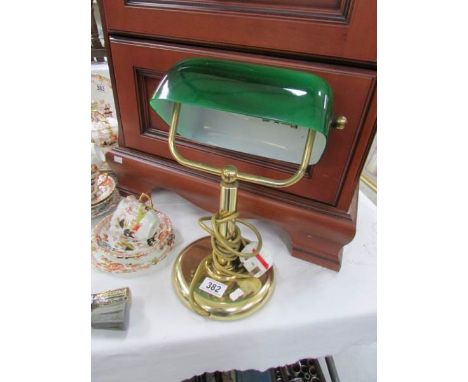 A banker's lamp with green glass shade.