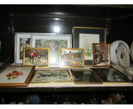 A shelf of framed and glazed prints.