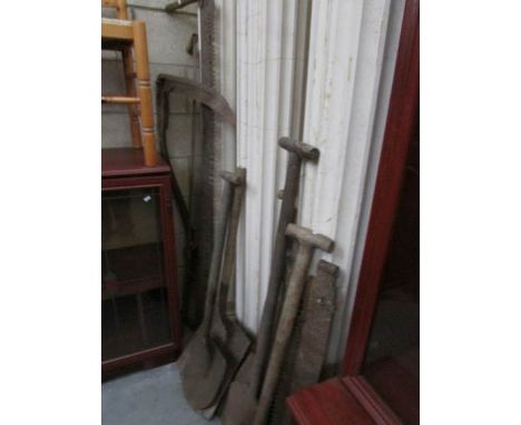 A mixed lot of garden tools including log saws.