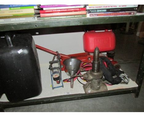 A shelf of miscellaneous car items including jack, foot pump etc.,