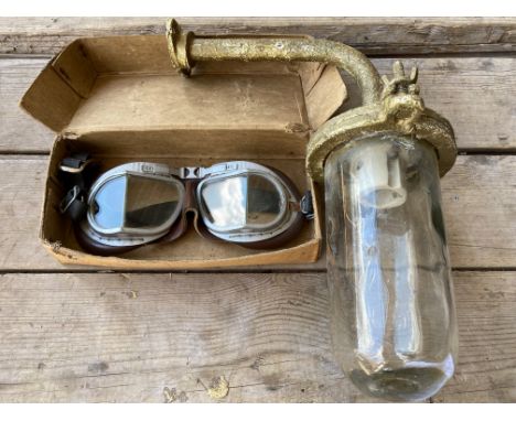 A boxed pair of Melton Mk. VIII goggles plus an exterior light from a garage.