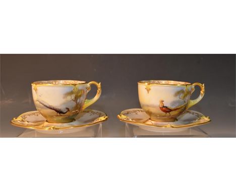 A pair of Royal Worcester cups and saucers signed A.Shuck, painted with scenes of pheasants. Height of cups 5.5cm. (4)
