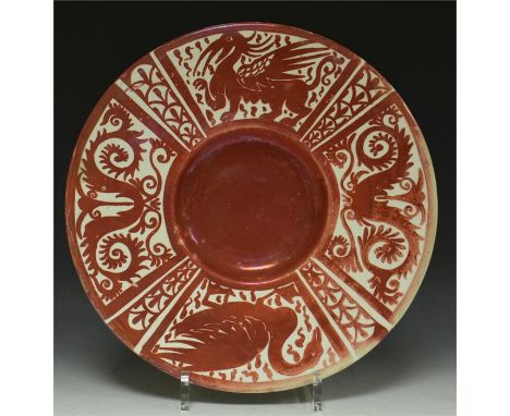 A William De Morgan ruby lustre charger, decorated with winged beast and bird, concentric circles to verso. Circa 1880, 30cm 