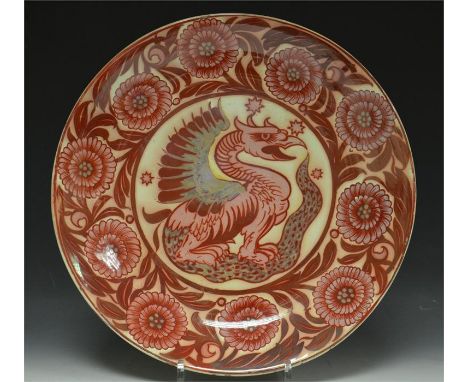 A William De Morgan ruby lustre charger, decorated with a dragon amongst floral borders, concentric circles to verso. Circa 1