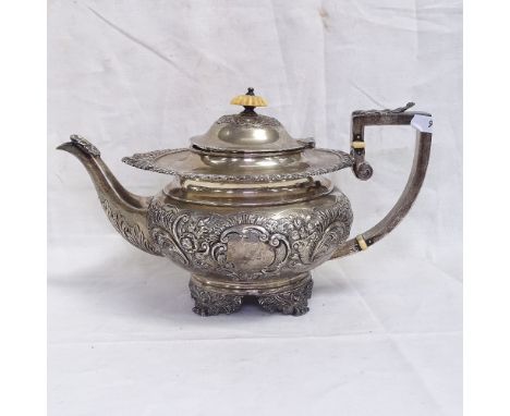 A George IV silver teapot, with cast edge floral relief decorated body on cast acanthus leaf feet with ivory knop, height 15.