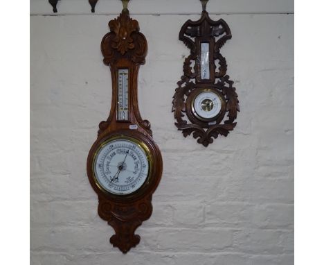 An Edwardian carved oak-cased aneroid wall barometer, and a Black Forest style barometer (2) 