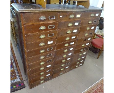 A Victorian stained pine bank of 33 drawers, with brass cup handles, W135cm, D35cm, H129cm 