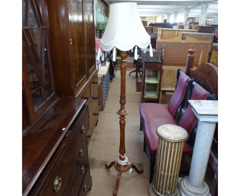 A carved and fluted stained pine standard lamp with tasseled shade, height including shade 178cm 