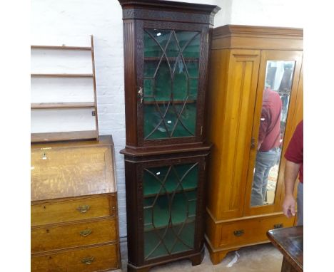 An Edwardian mahogany 2-section corner cabinet, in Chippendale style, with blind carved fretwork panels, and 2 lattice-glazed