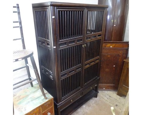 An Oriental design hardwood 2-section cabinet, with turned spindle panels and 2 doors, with drawers under and shelf below, W1