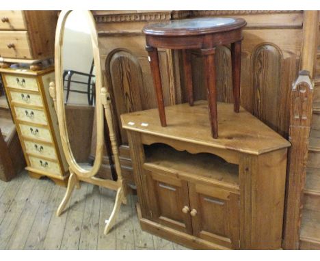 A modern light oak oval cheval mirror and a large pine two door corner TV unit and an occasional table with unusual clock fac