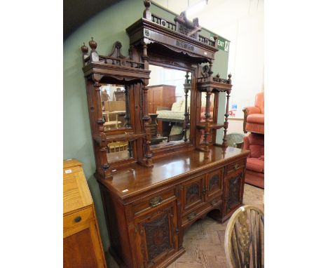 An ornately carved mahogany mirror and shelf back sideboard.  The base has two central cupboard doors over a single drawer fl